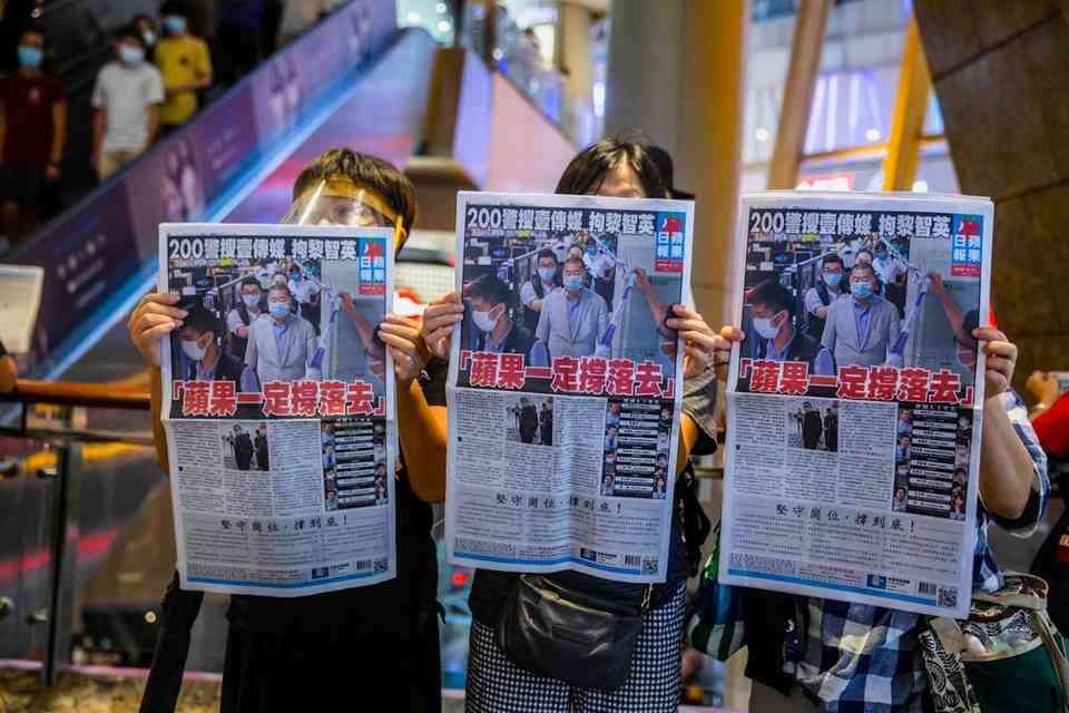 People hold up copies of the Apple Daily as they protest for press freedom, inside a mall in Hong Kong, on Aug. 11, 2020.