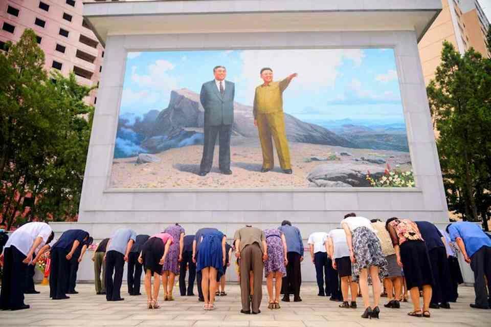 Men and women bow before a mosaic depicting former North Korean leaders Kim Il-sung and Kim Jong-il in Pyongyang on Thursday on the 27th anniversary of the death of Kim Il-sung.